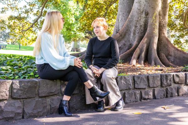 A young person speaking to a YDAS advocate at a park.