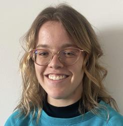 Julie, a short statured young person with blonde hair and glasses