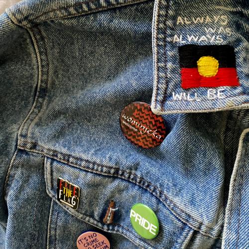 A denim jacket with an Aboriginal flag embroidered onto it.