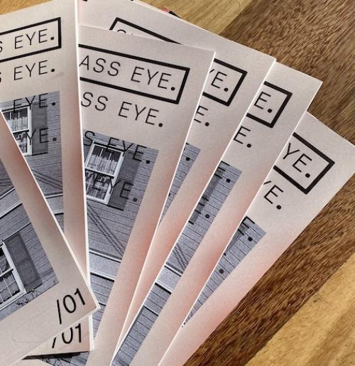 6 A5 zines spread across a mid-stain wooden table.