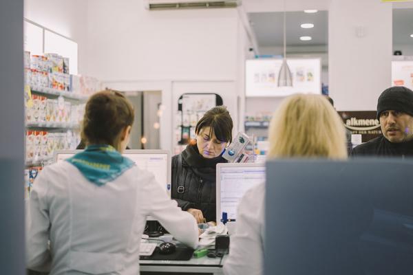 Customers purchase products from a pharmacy