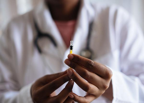 Nurse holding vaccine syringe